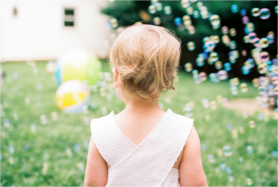 toddler playing in backyard with bubbles